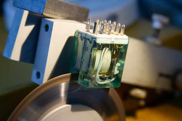Cutting into an electromagnetic relay with a diamond saw (Outtake)
